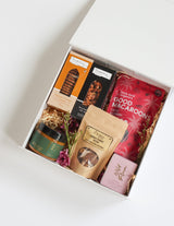 The Wild flower Luxury Treat Box featuring gourmet cookies, nuts, crackers, macaroons, chocolates, honey, and a candle.
