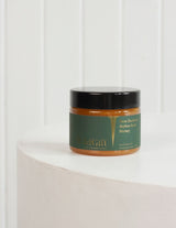 The Wild flower Wild Gift New Zealand Native Bush Honey in a glass jar with a green label on a white pedestal.