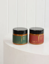 Two jars of The Wild flower Wild Gift New Zealand honey, one Native Bush and one Wildflower, on a white pedestal.