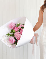 The Wild Flower Peonies Bouquet in white paper with the signature dandelion tag
