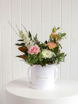 The Wild flower Wild Flower Box featuring a seasonal arrangement of pink roses, white chrysanthemums, and greenery.