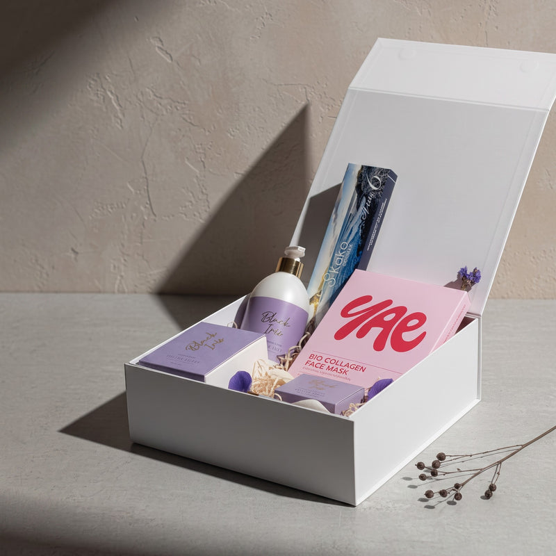 The Wild flower Treat Her wellness gift box featuring Living Light skincare, YAE face mask, and Kāko artisan chocolate.