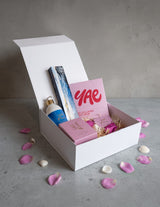 The Wild flower Treat Her Wellness Box featuring Living Light skincare, YAE face mask, and Kāko chocolate in a gift box