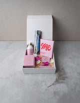 The Wild flower Treat Her wellness gift box featuring Living Light skincare, YAE face mask, and Kāko artisan chocolate.