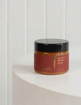 The Wild flower Wild Gift New Zealand Wildflower Honey in a glass jar with a red label on a white pedestal